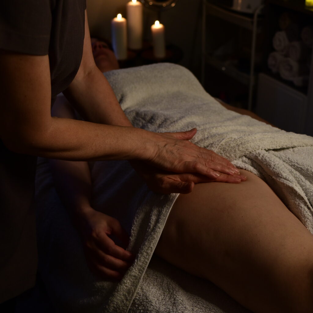 Therapist performing manual lymphatic drainage by gently massaging the lymph nodes in the groin area.